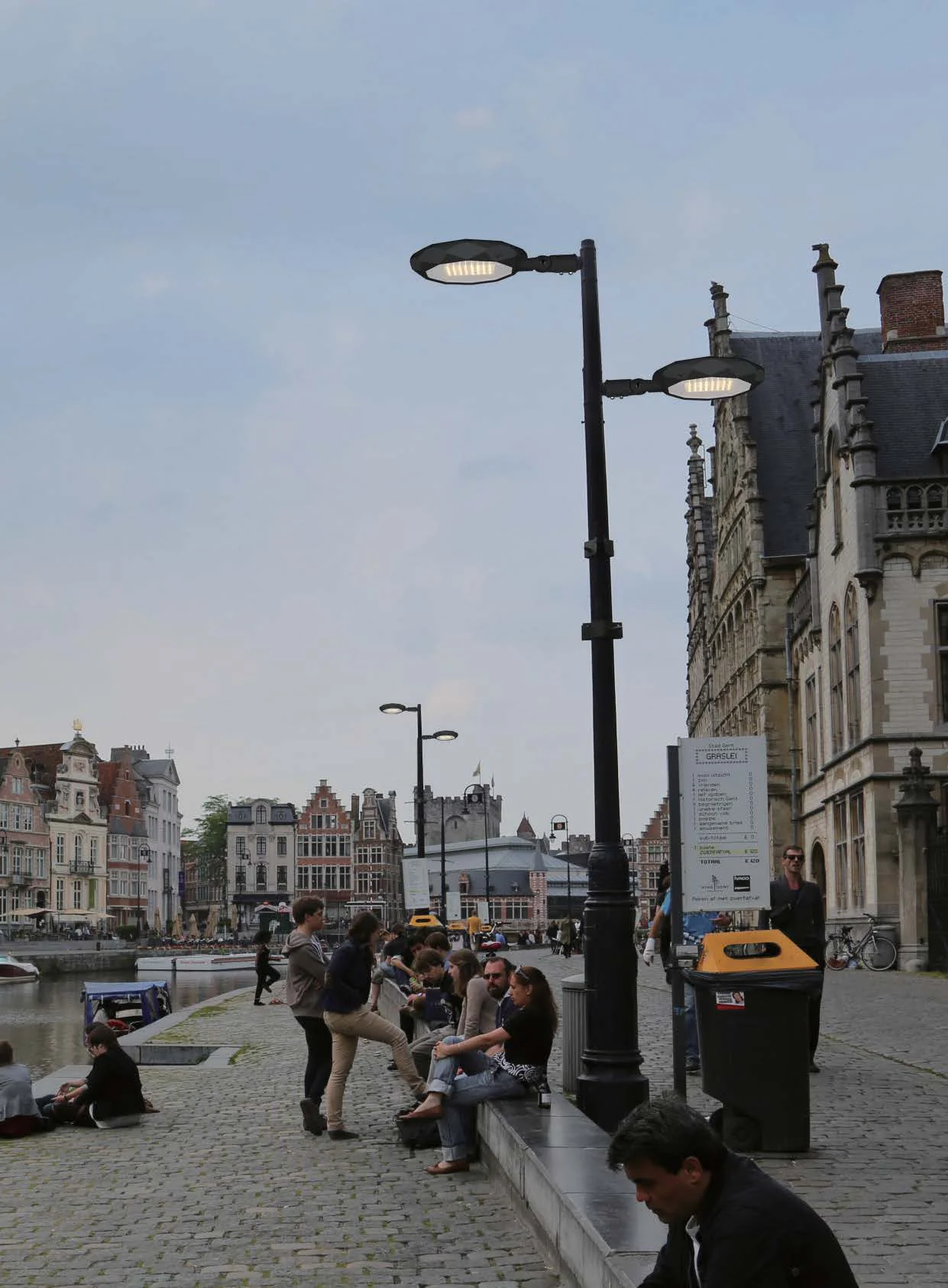 LUXIFIC catalogue application visual showing a MANTIS-L decorative luminaire beside an urban plaza