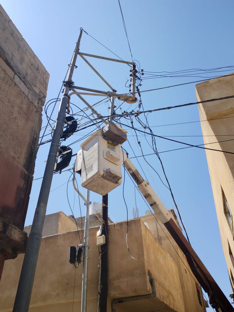 Installation technician positioning a luminaire on a municipal pole in Asia