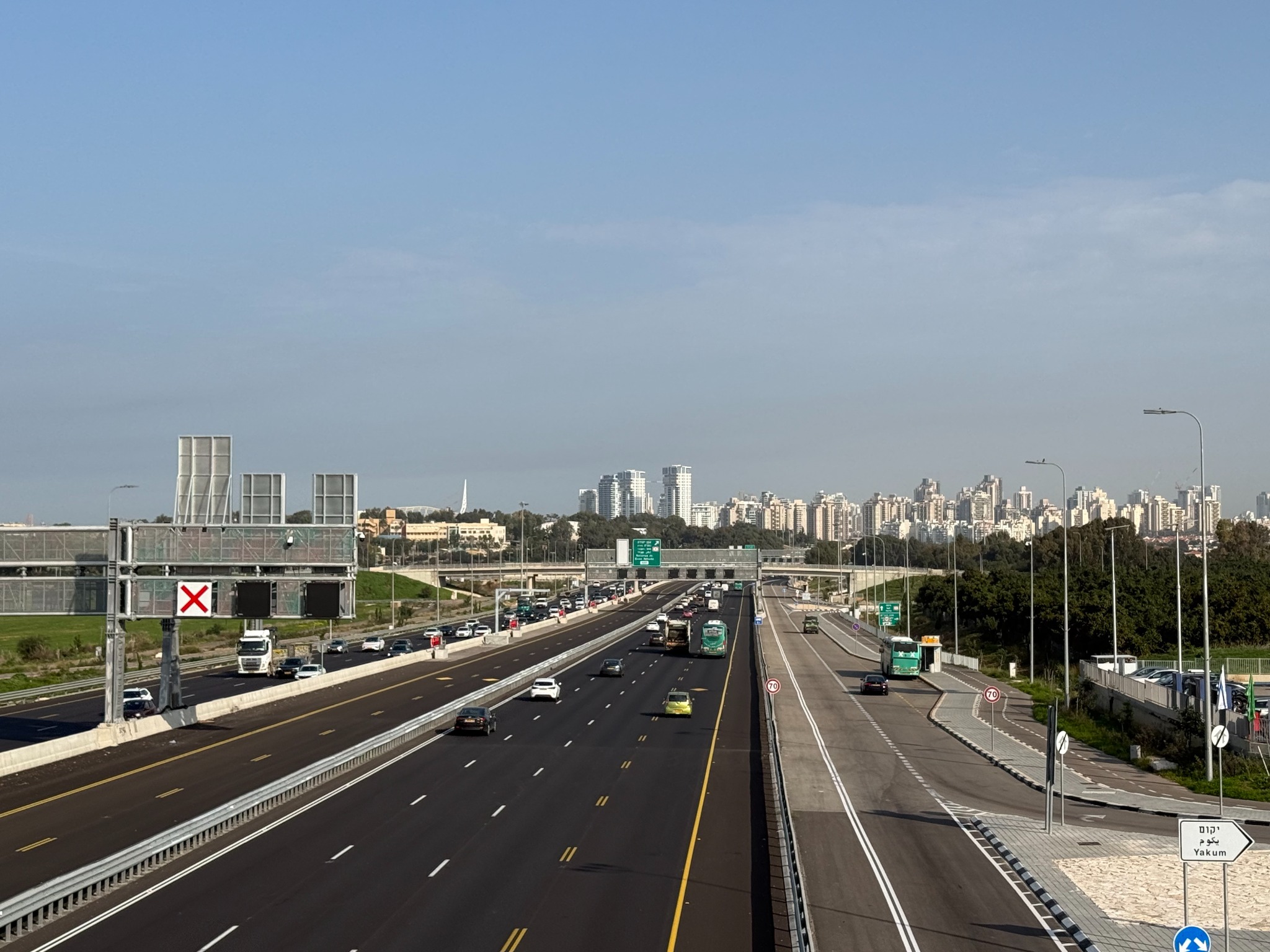 Daytime view of a multi-lane roadway and its roadside LED luminaires in the Middle East