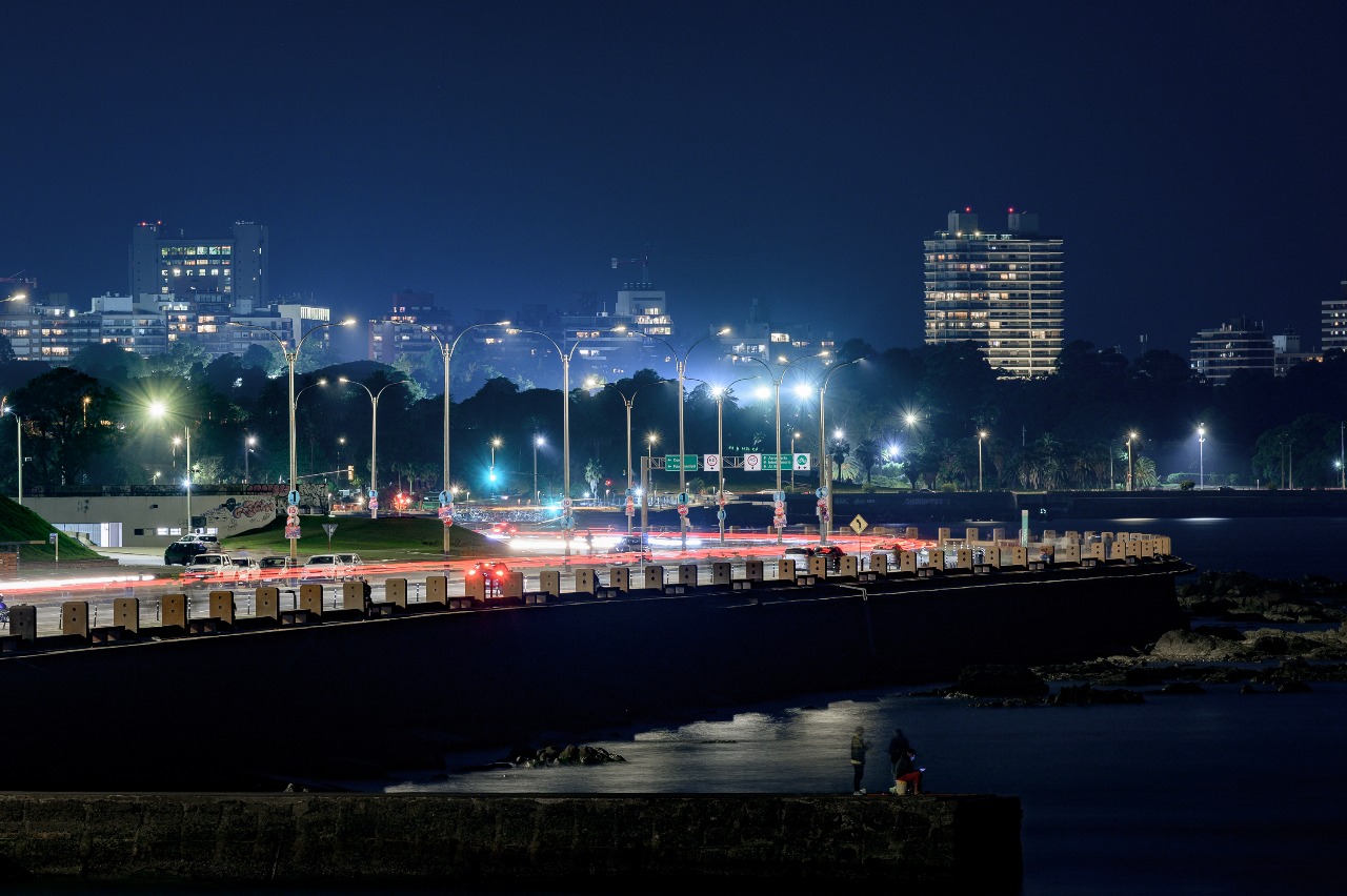 Illuminated coastal traffic route and double-arm street-lighting poles in the municipality at night