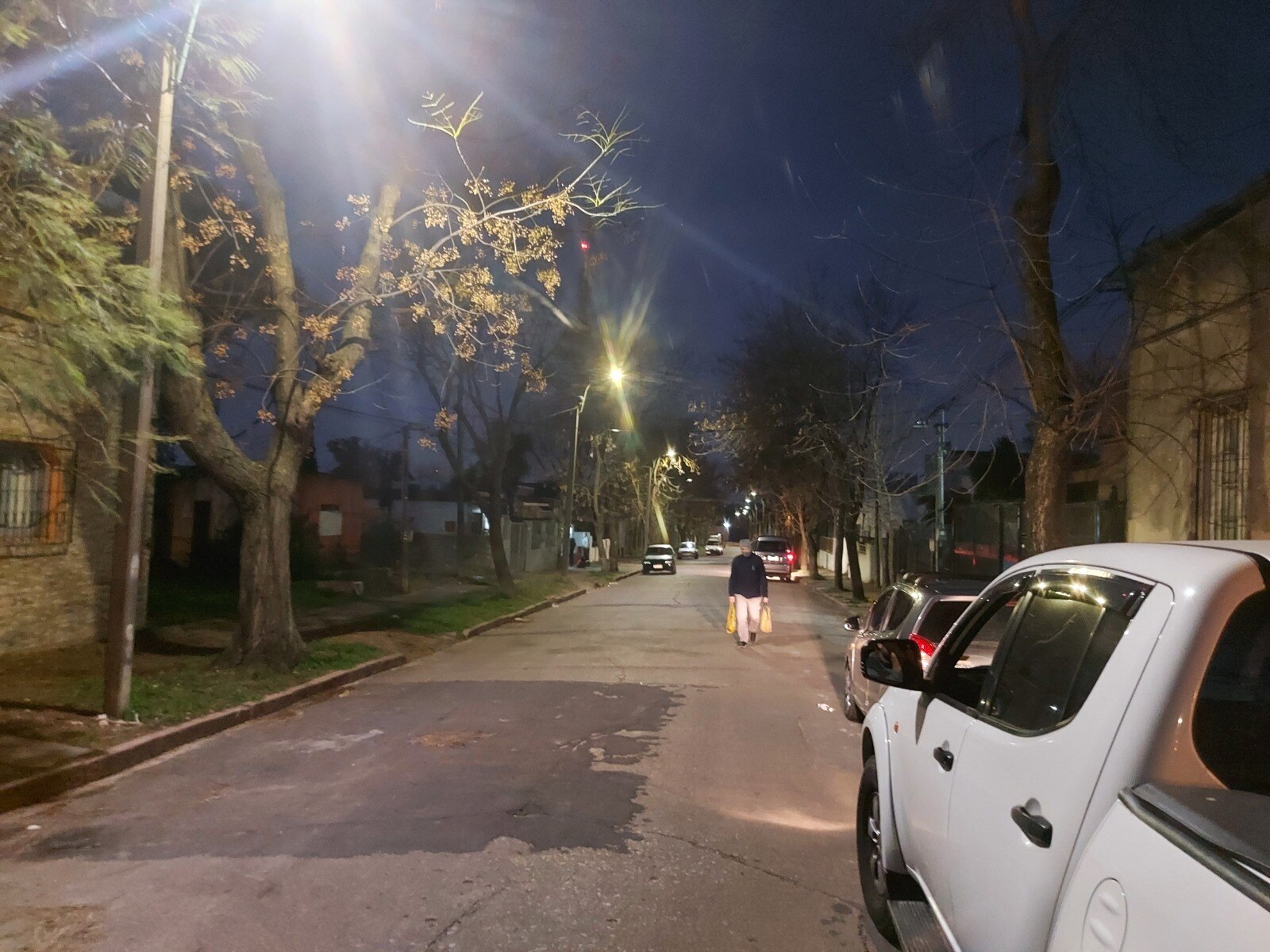 Installed LED street lights illuminating a residential road in South America at night